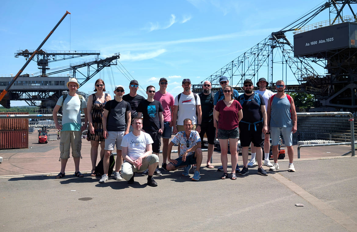 Gruppenfoto vom clickstorm Sommerfest 2026 in Ferropolis mit den Baggern im Hintergrund