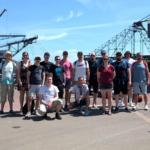 Gruppenfoto vom clickstorm Sommerfest 2026 in Ferropolis mit den Baggern im Hintergrund