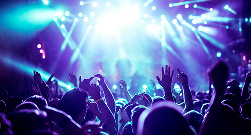 Personen feiern beim Konzert mit Blick zur Bühne